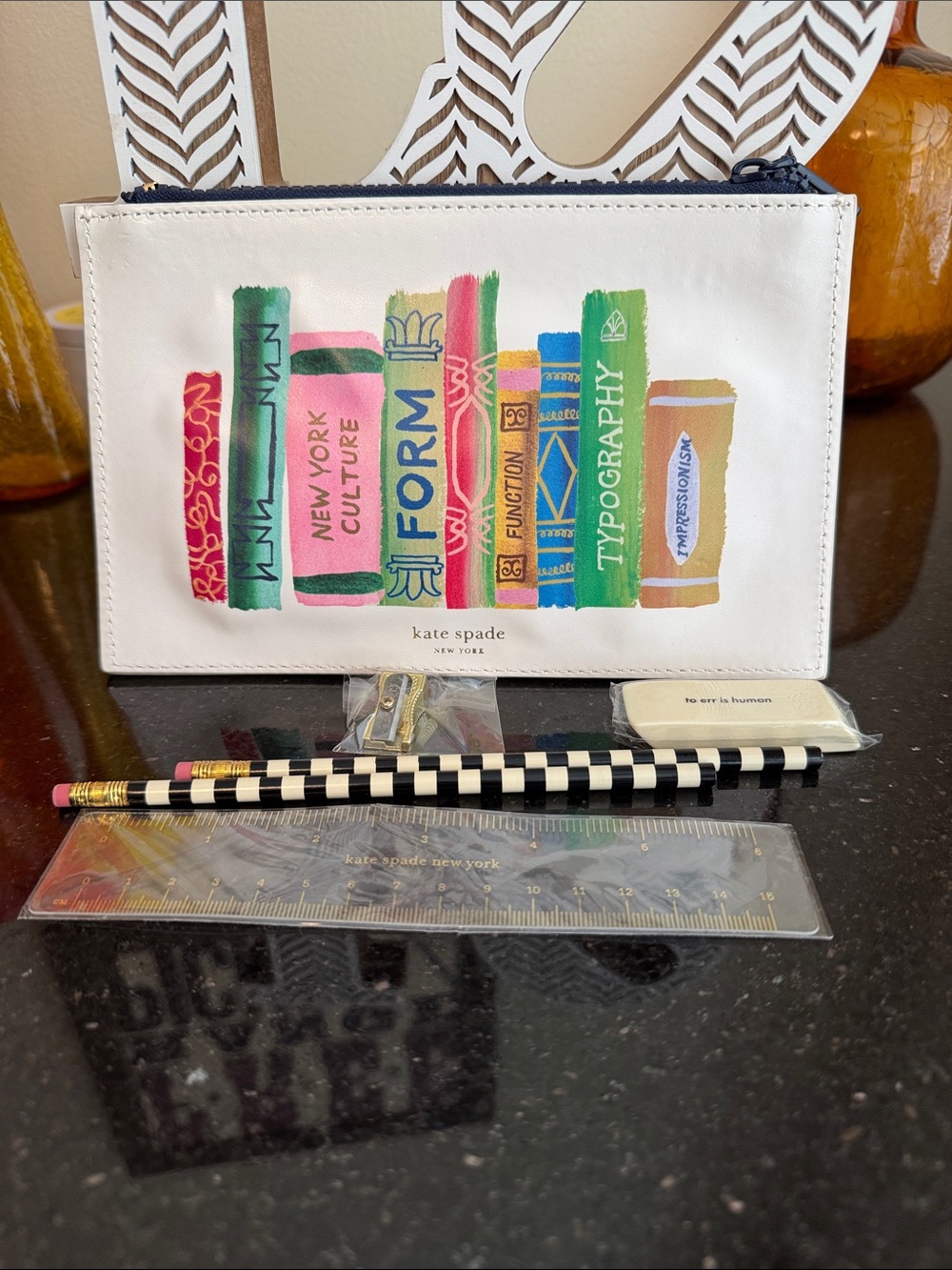 kate spade white pouch with colorful book spine print